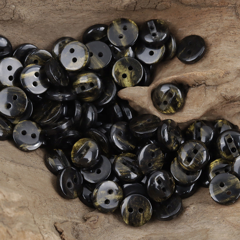 Two-hole black resin buttons with gold flecks, glossy round discs with two holes