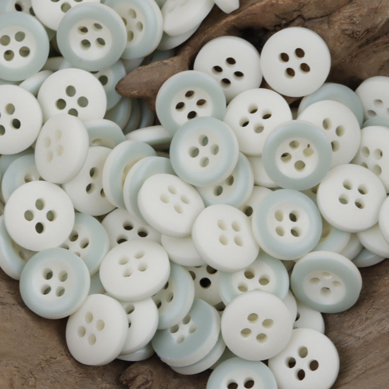 Light blue round resin buttons with 4 holes, clustered assortment