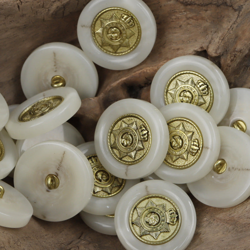 White resin buttons with gold star crown pattern and small gold shank detail