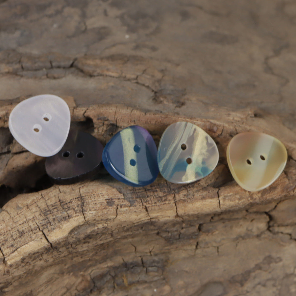 Iridescent irregular triangle buttons, 2-hole in white, blue, and cream-yellow tones