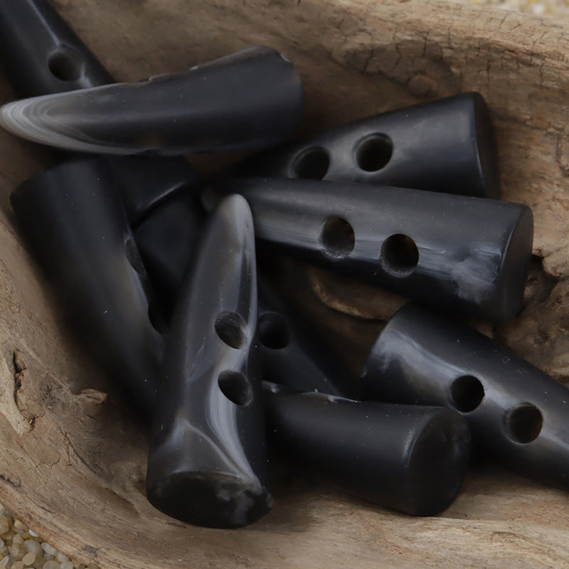 Set of horn-shaped resin toggle buttons, dark finish, with multiple hole details