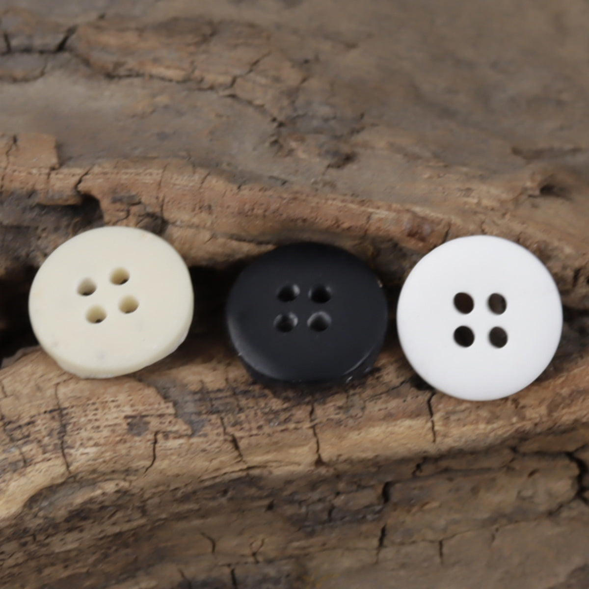 White and black moon-surface resin buttons, round with four holes, 3-pack view