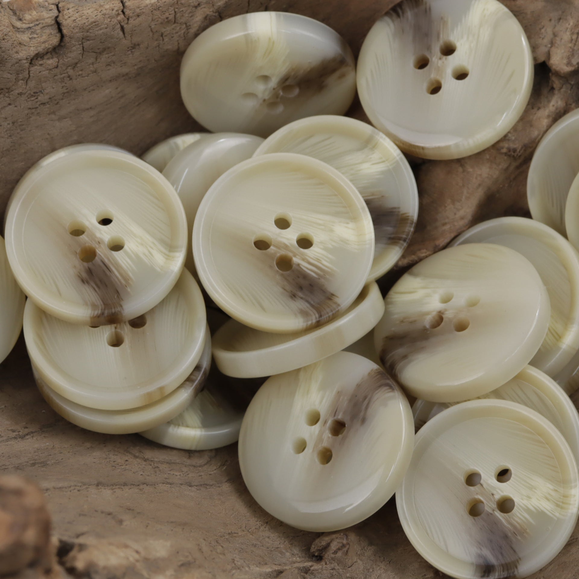 Light khaki round resin buttons, 4-hole fronts, assorted bunch in a pile