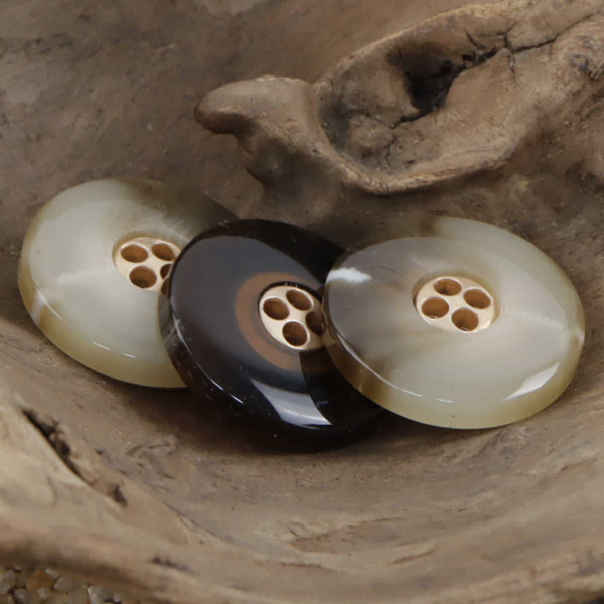 Resin-metal coat buttons in khaki and coffee tones, each round with four holes