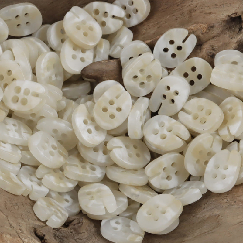 White fish-mouth resin buttons, four-hole design, assorted pile