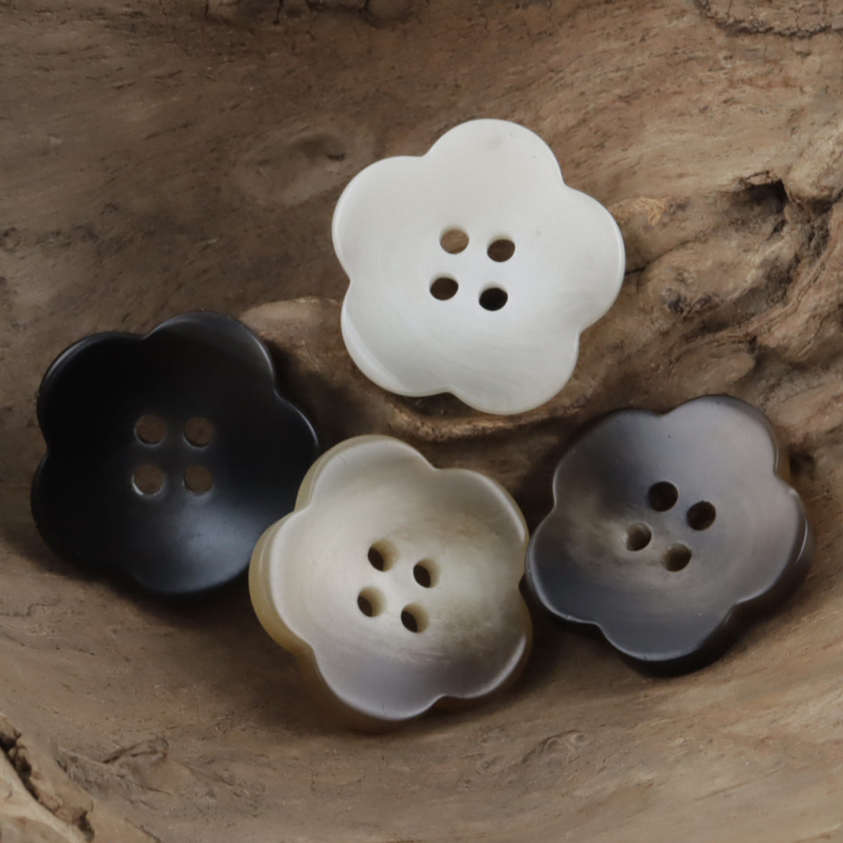 Flower-shaped resin buttons in white, dark and gray tones, each with 4 holes