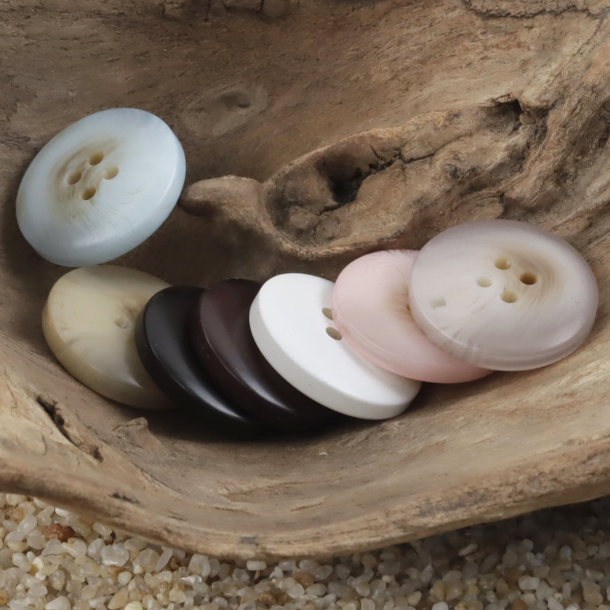 Assorted round resin buttons with 4 holes in white, cream, pink, and dark colors