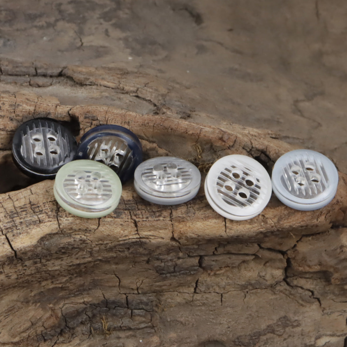 11.5mm transparent resin 4-hole buttons showing front views in light and dark shades