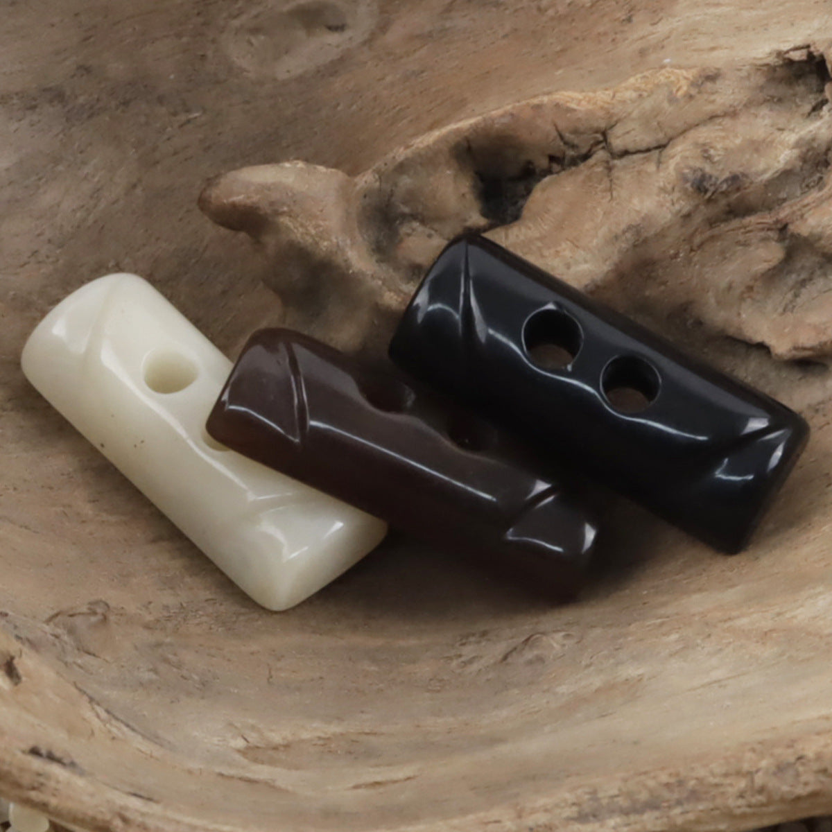 Two-hole toggle resin buttons in beige, coffee, and black
