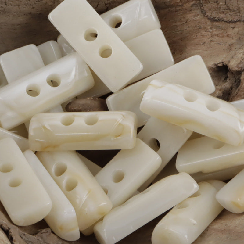 Beige/cream semi-cylindrical 2-hole toggle resin buttons