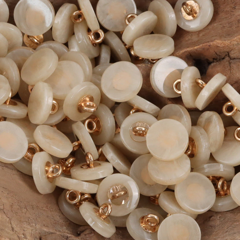 Round resin shank buttons pile in beige/cream with gold-tone shanks