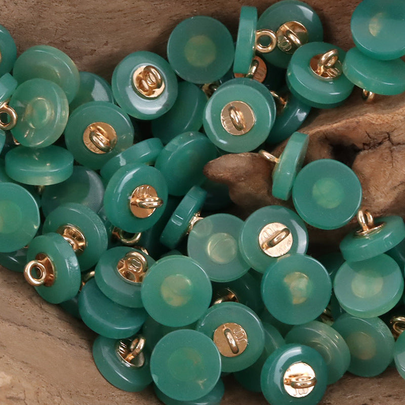 Round resin shank buttons pile in green with gold-tone shanks