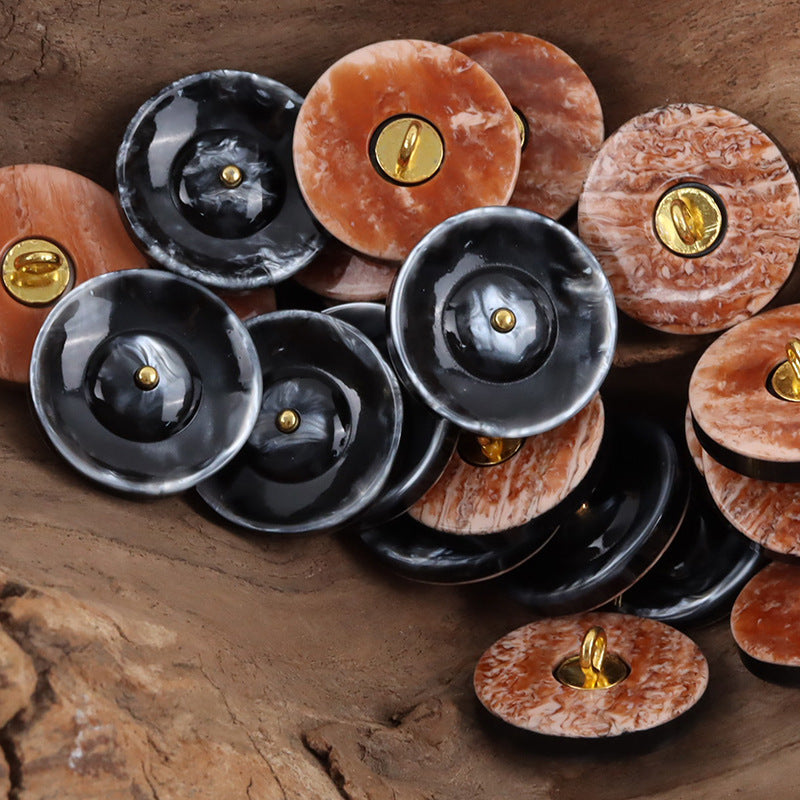 Assorted round resin curtain buttons in black and beige yellow with gold metal shanks