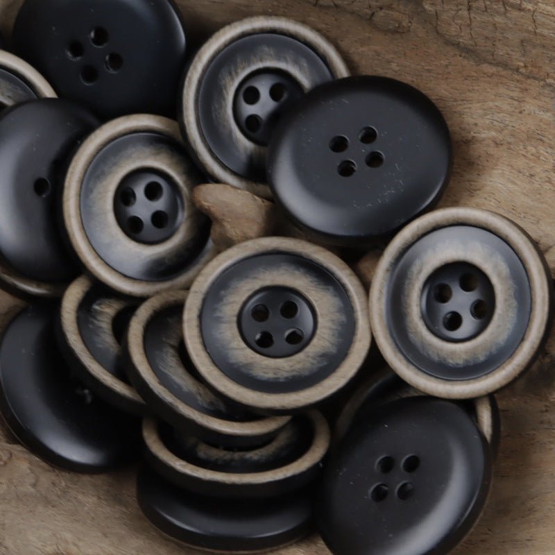 Frosted 4-hole resin buttons, dark gray faces with light gray edges, close-up