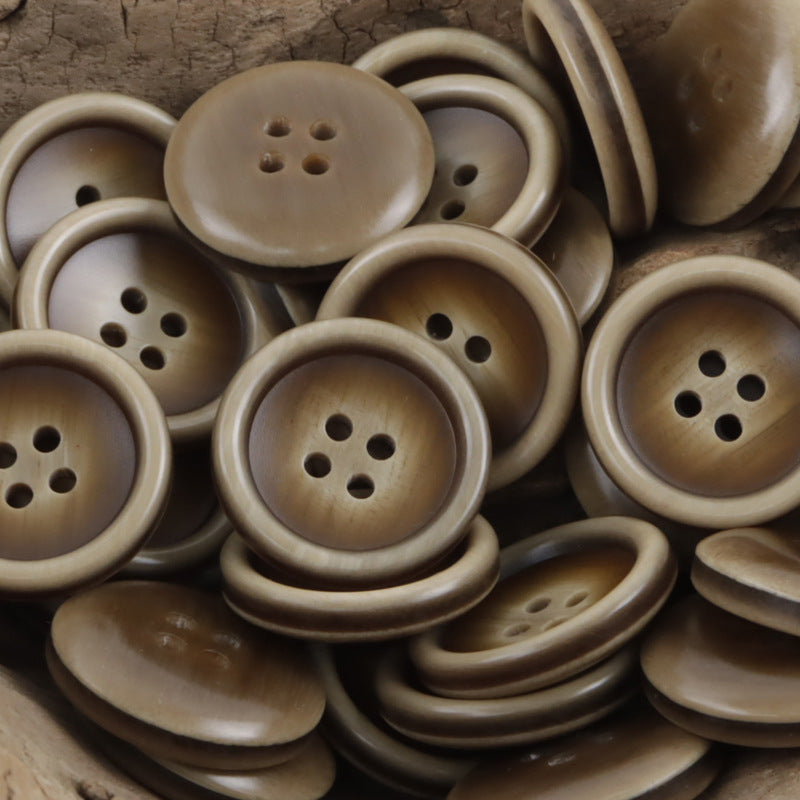 Light coffee round resin suit buttons, 4-hole faces in a stacked pile