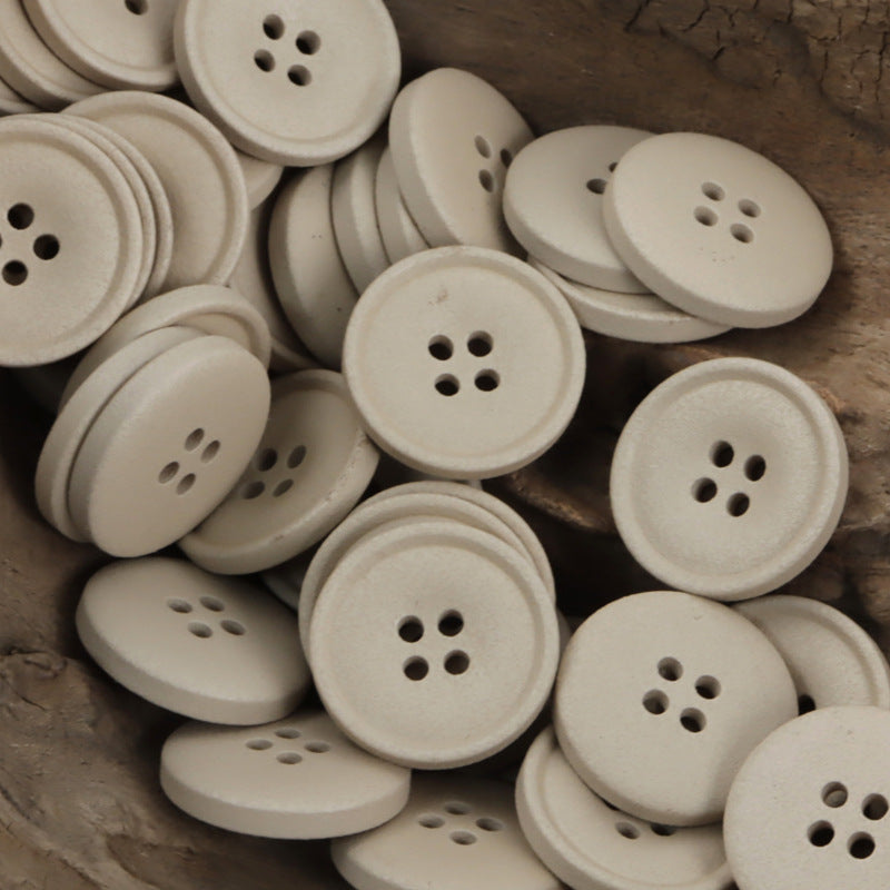 Matte resin coat buttons in light cream/beige with round 4-hole fronts