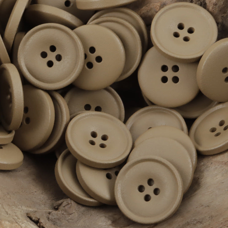 Matte resin coat buttons in khaki/tan shades with round 4-hole fronts