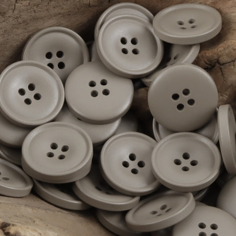 Matte resin coat buttons in light gray shades with round 4-hole fronts