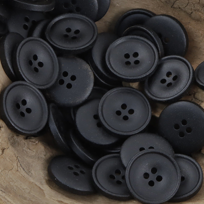 Matte resin coat buttons in black with round 4-hole fronts