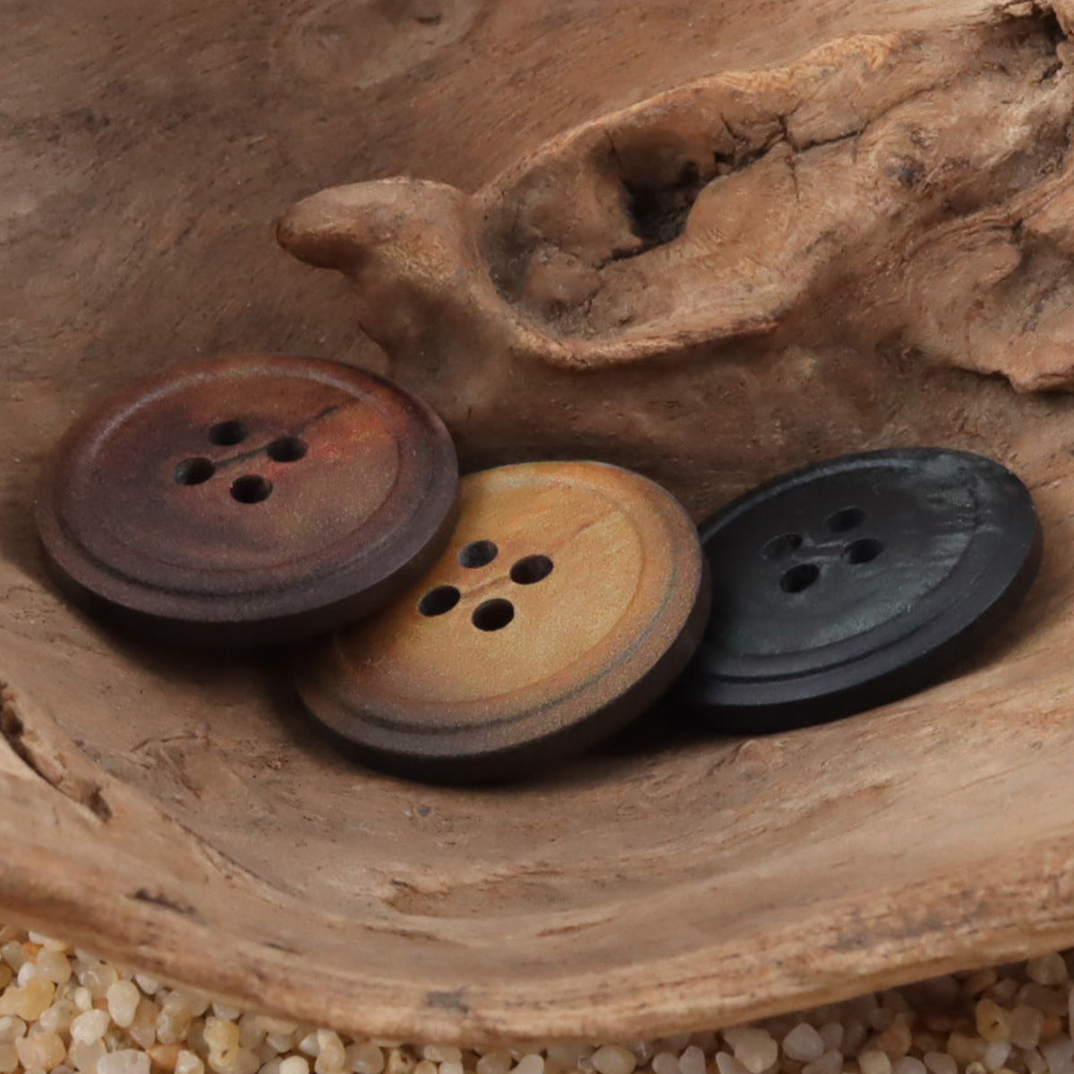 Close-up of round 4-hole vintage resin buttons: coffee-brown, burnt yellow, and black