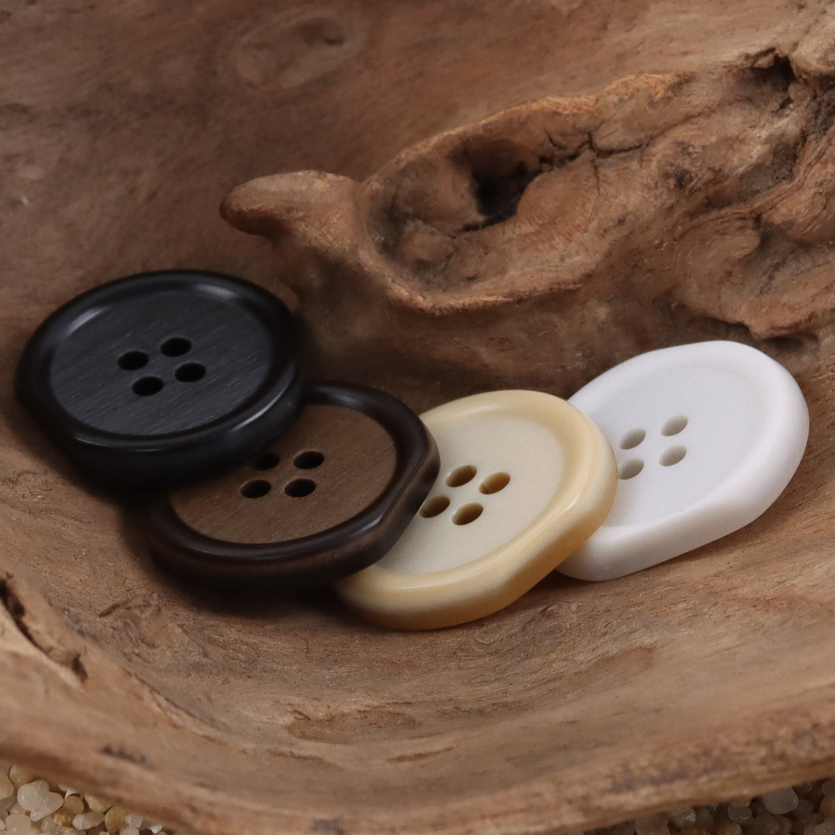 Four-hole resin buttons mix: dark brown/black, cream, and white close-up