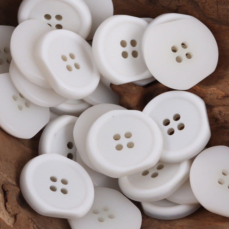 White irregular four-hole resin buttons, multiple views with stitched hole pattern