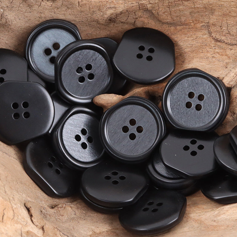 Black and dark gray irregular four-hole resin buttons, multiple pieces close-up