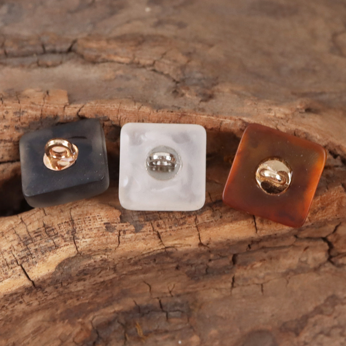 Front view square resin buttons with metal shanks: black, white, amber buttons