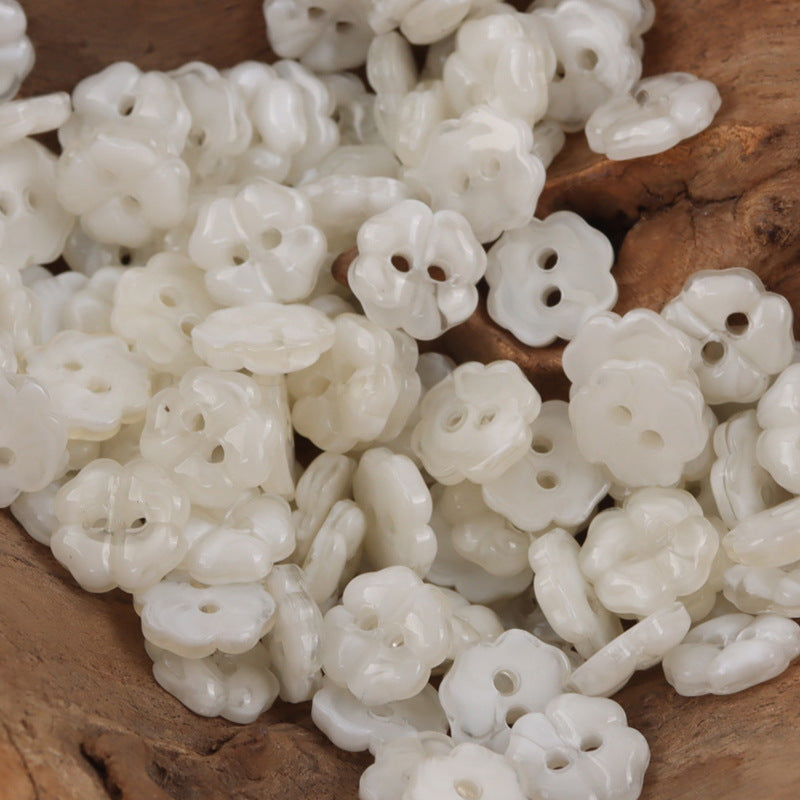 Close-up of white cherry blossom resin buttons with two holes