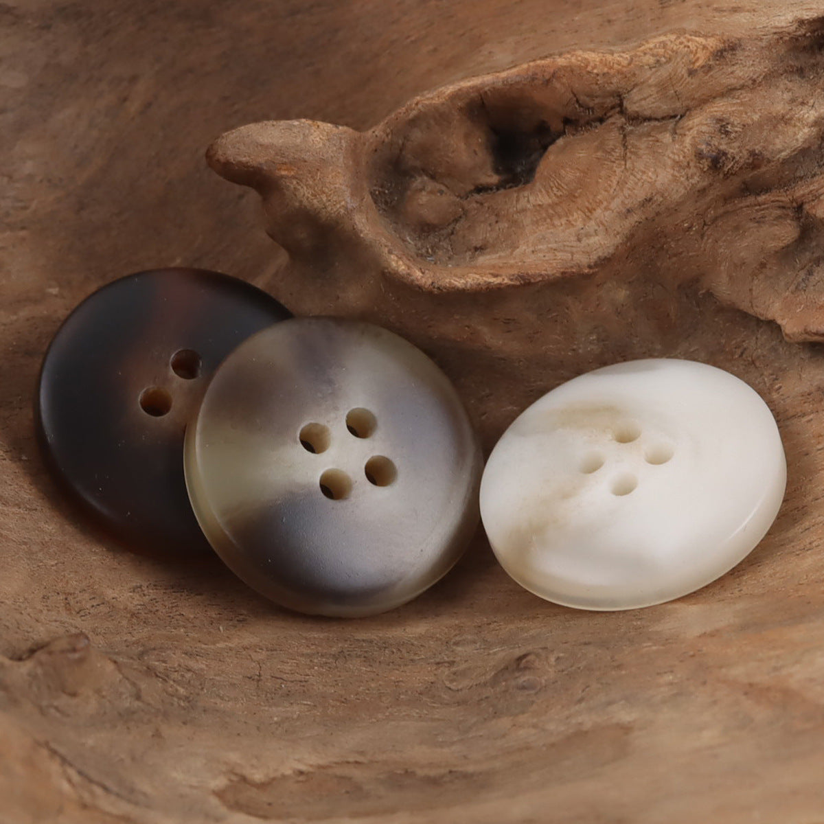 Round 4-hole resin buttons in dark brown, gray, and white with gold-tone shank