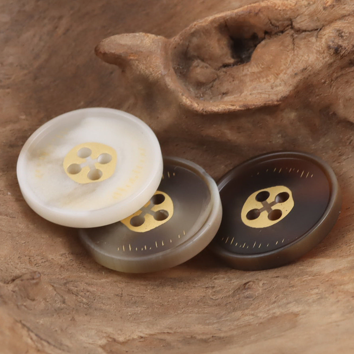 Round 4-hole resin buttons: white, gray-beige, and dark brown with gold-tone shank