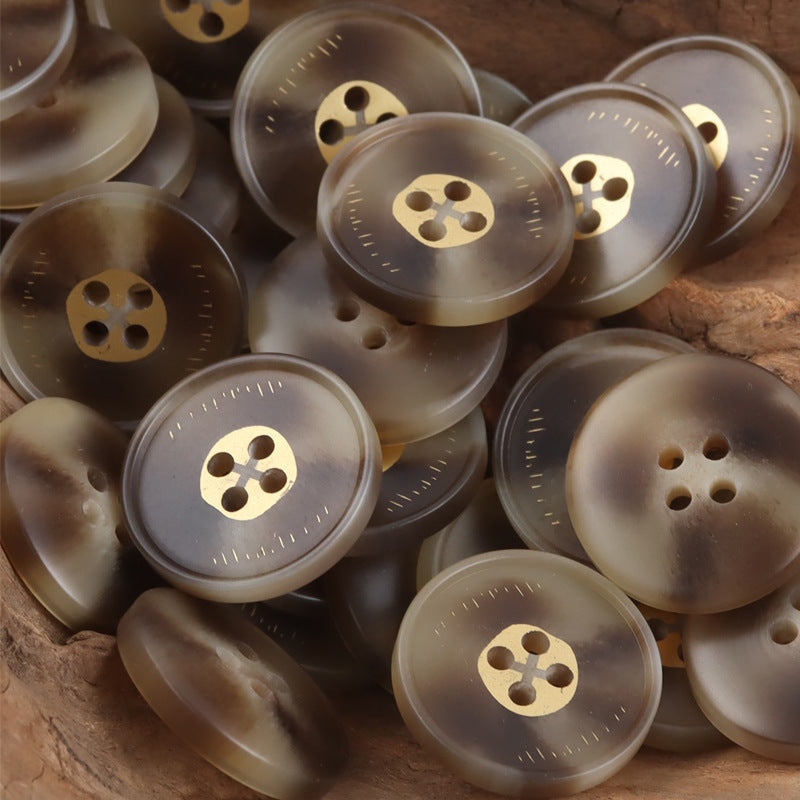 Assorted round resin buttons with four holes and gold-tone shank in dark and light gray