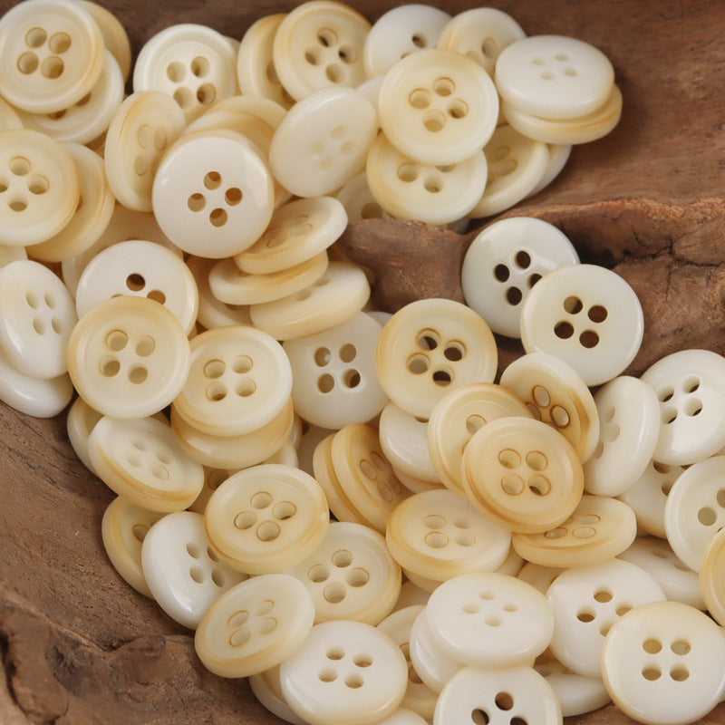 Assorted beige round resin buttons with four-hole and three-hole cutouts