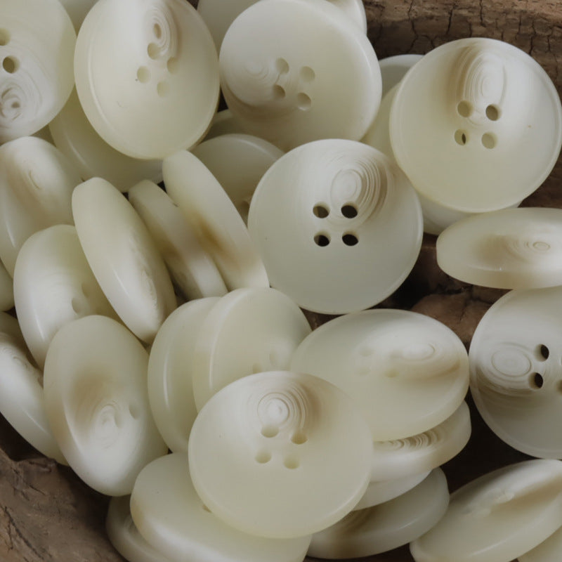 Off-white resin buttons, rounded 4-hole fronts, close-up of multiple pieces
