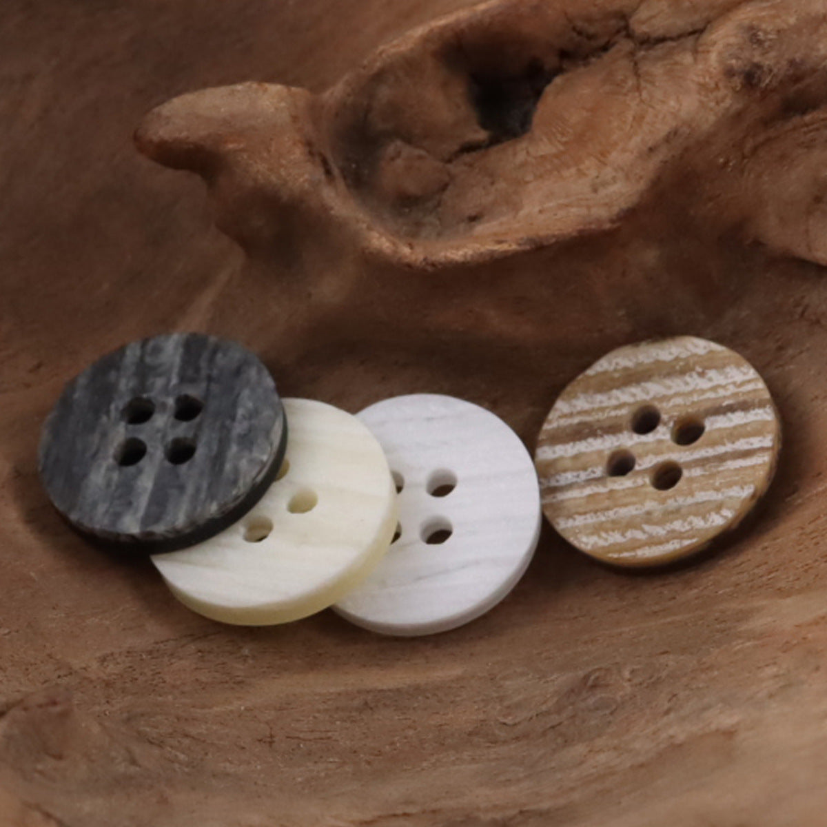 Round 4-hole resin buttons in dark gray, white, light beige, and tan wood-grain tones