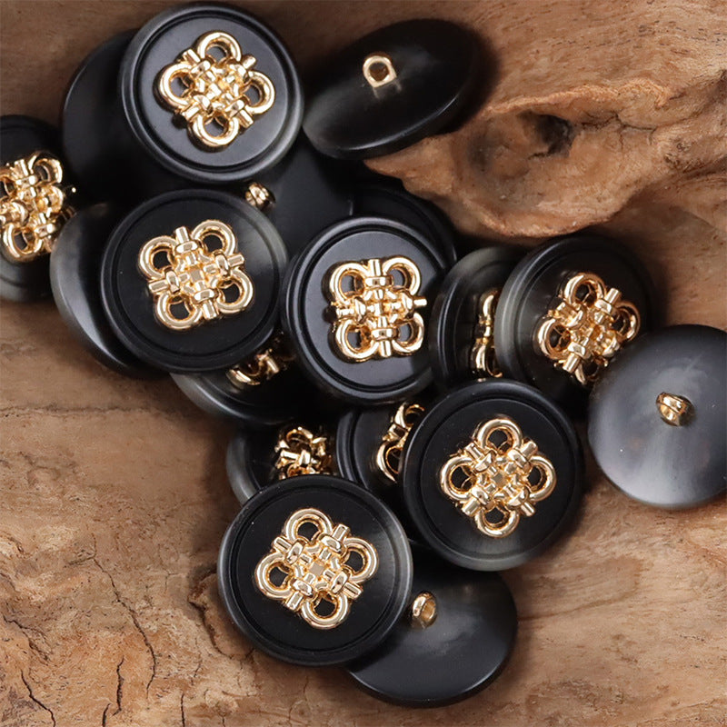 Black resin coat buttons with gold-tone Chinese knot metal fronts and metal shanks, scattered