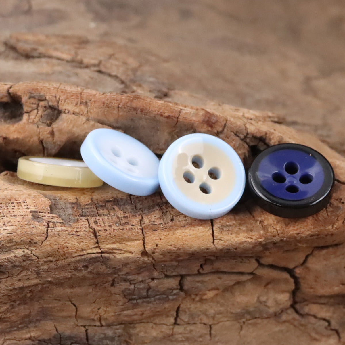 Light blue and cream 4-hole resin bowl buttons with one dark blue button