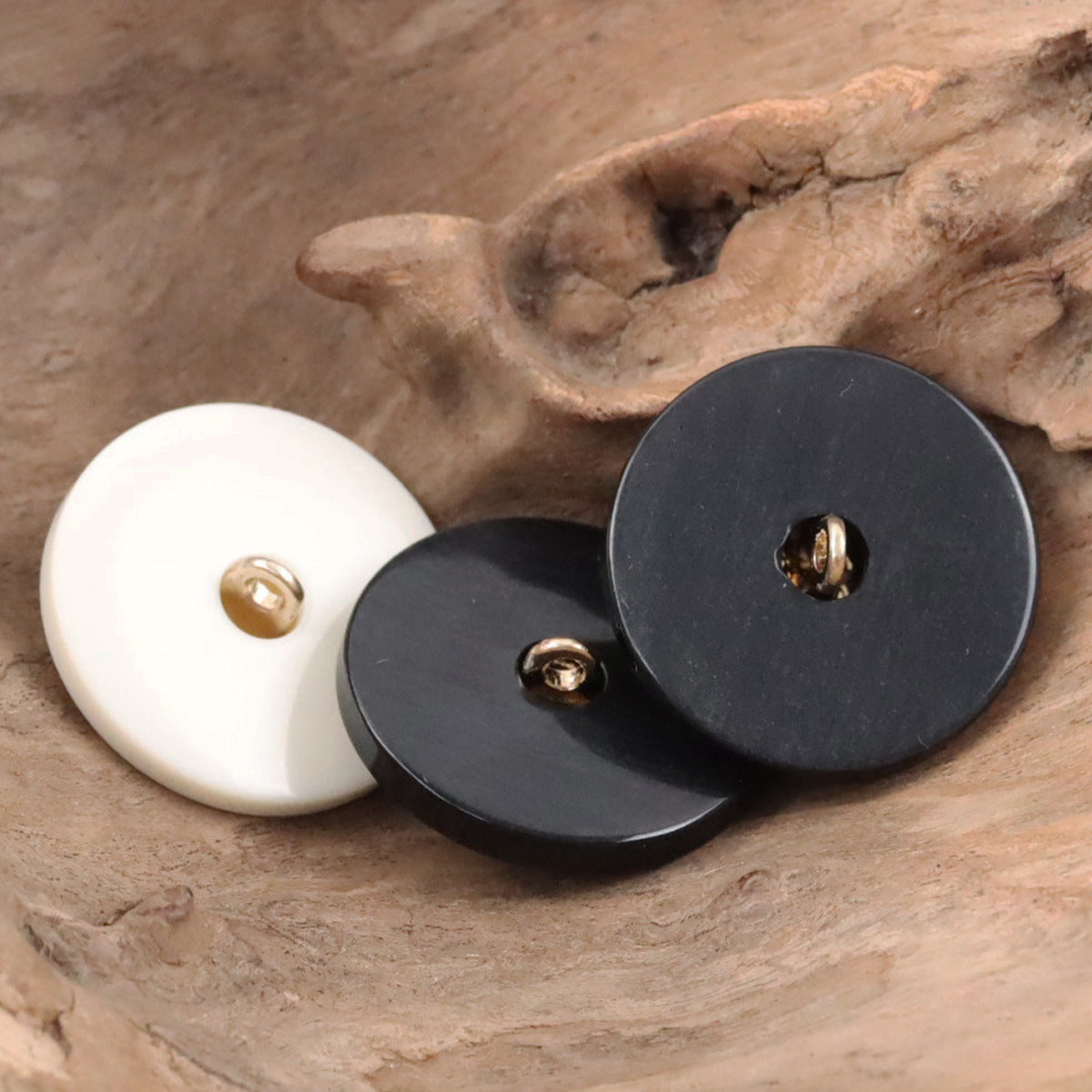 Round resin buttons with gold clover, metal shanks; one white and one dark
