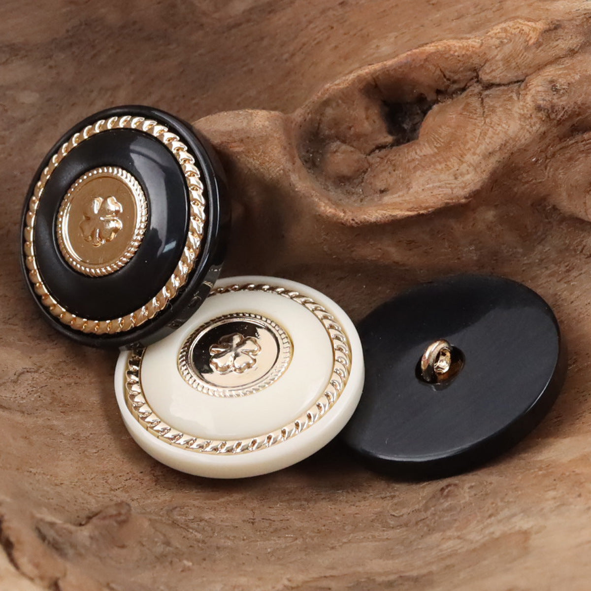 Black and white round resin buttons with gold clover centers and metal shanks
