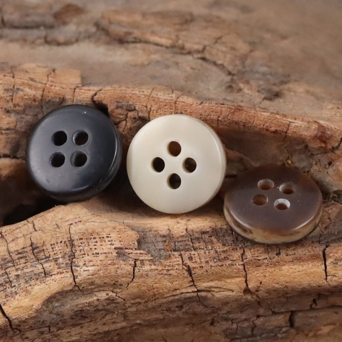 Round resin buttons: matte black, khaki/cream, and coffee-brown with four holes