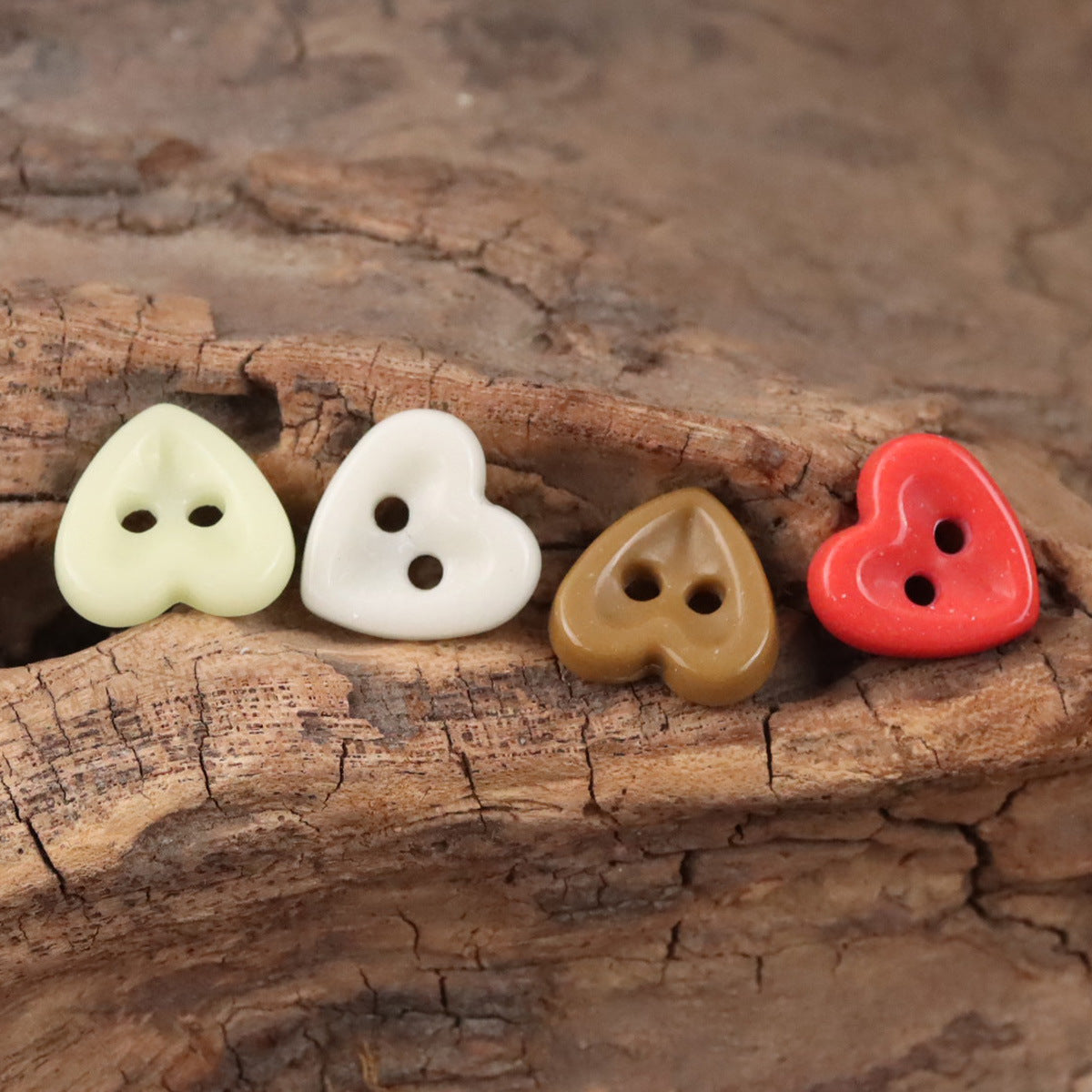 Ceramic heart buttons in cream, white, tan, and red, each with two holes.