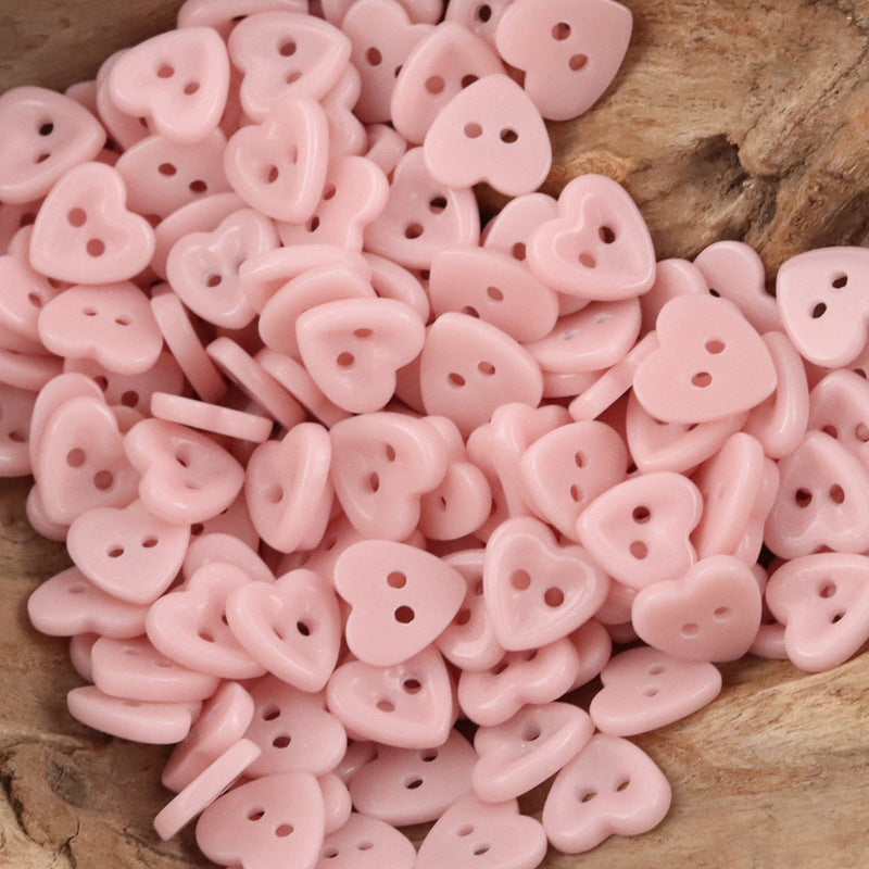 Ceramic heart buttons—light pink style with two holes and flat backs, mixed pile.