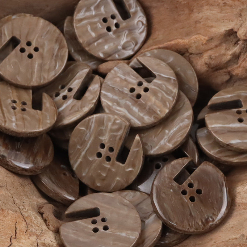 Wood-grain resin buttons in warm light-brown tones, round with side notch and holes