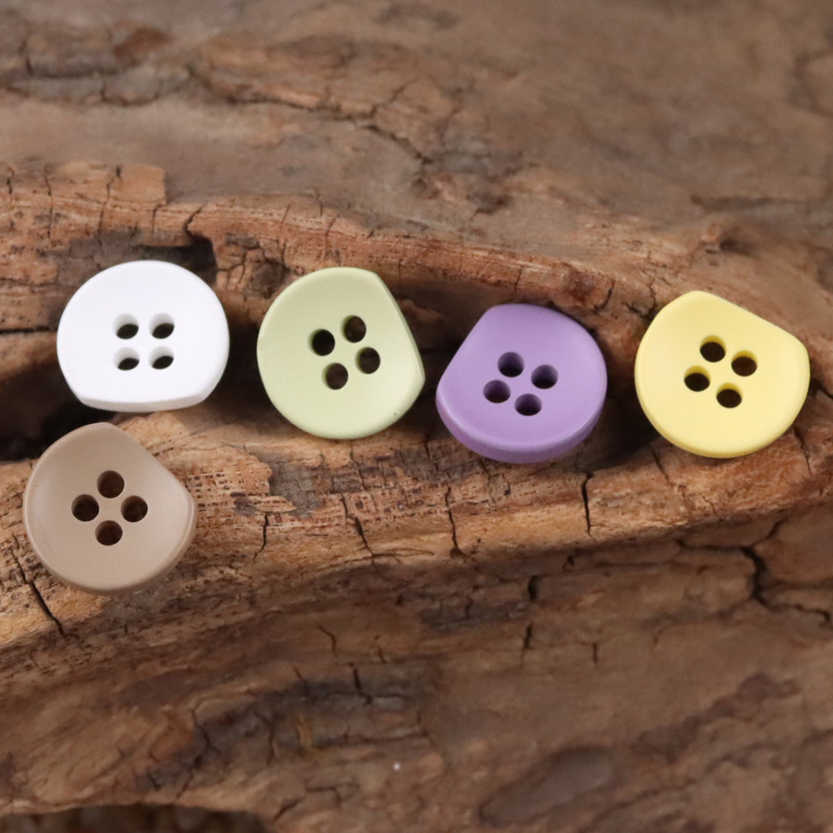 Semi-circular resin buttons in white, green, purple and yellow, four-hole style