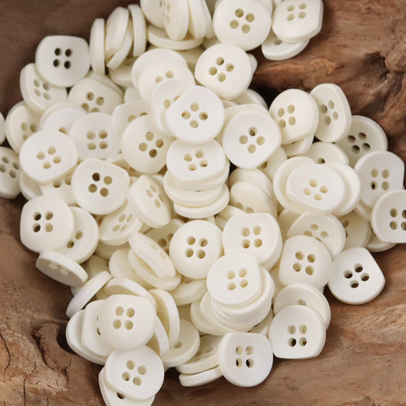 Bulk resin buttons, white with four-hole design, round semi-circular style