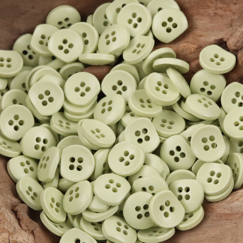 Light green round resin buttons with four-hole design, bulk set for handicrafts