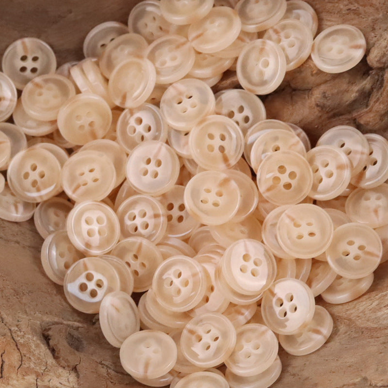 Pile of semi-transparent resin shirt buttons, light beige/peach, four-hole