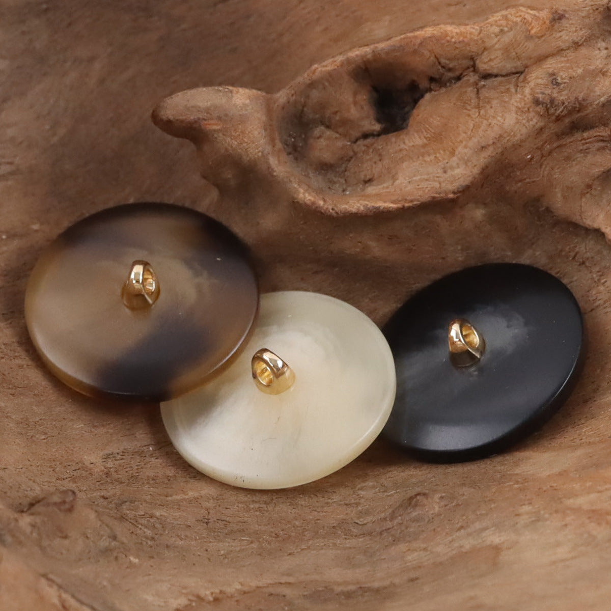 4 resin buttons with metal shanks: taupe, cream, white, and dark navy bases with gold tone