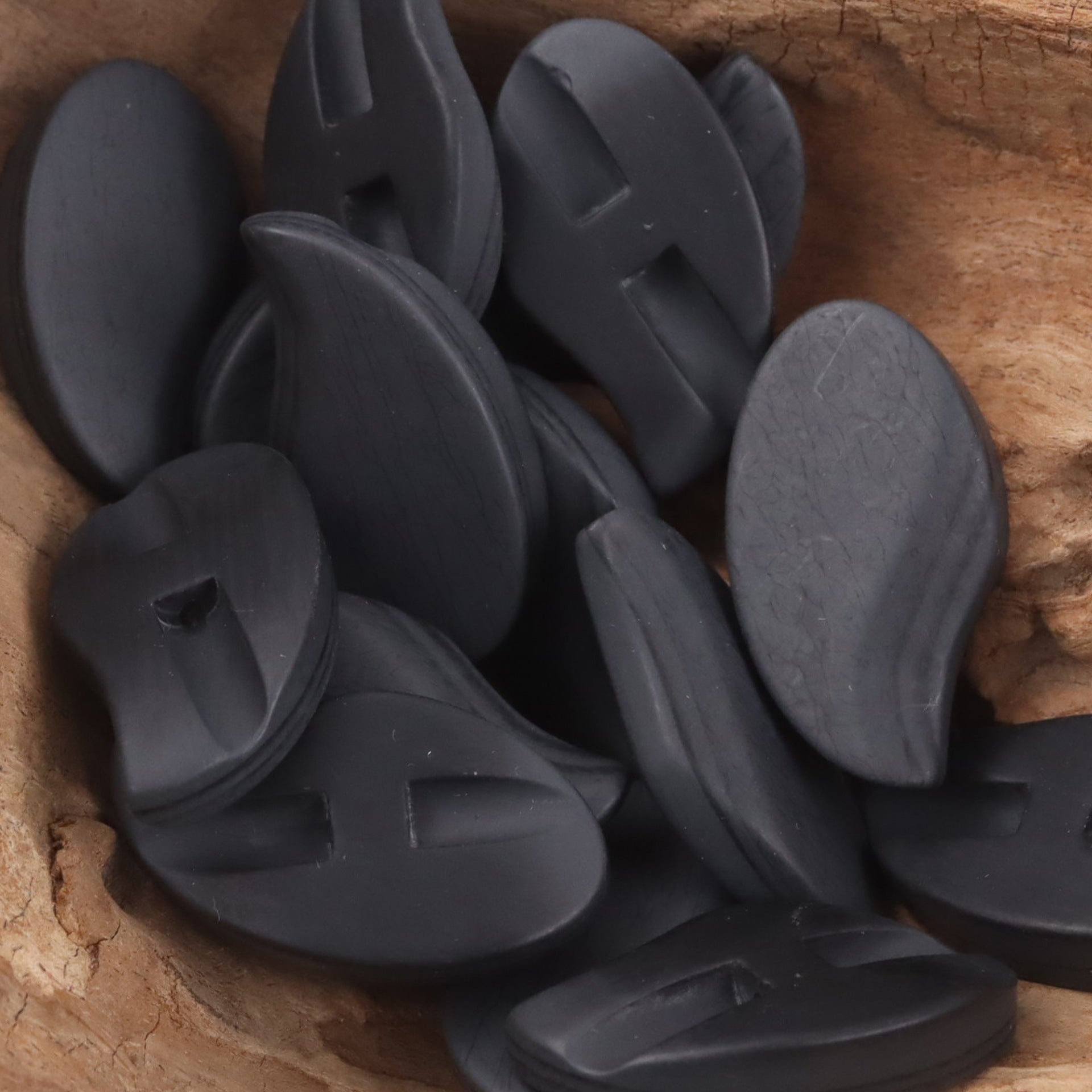 Black comma-shaped matte resin shank buttons, matte finish with slit shank holes