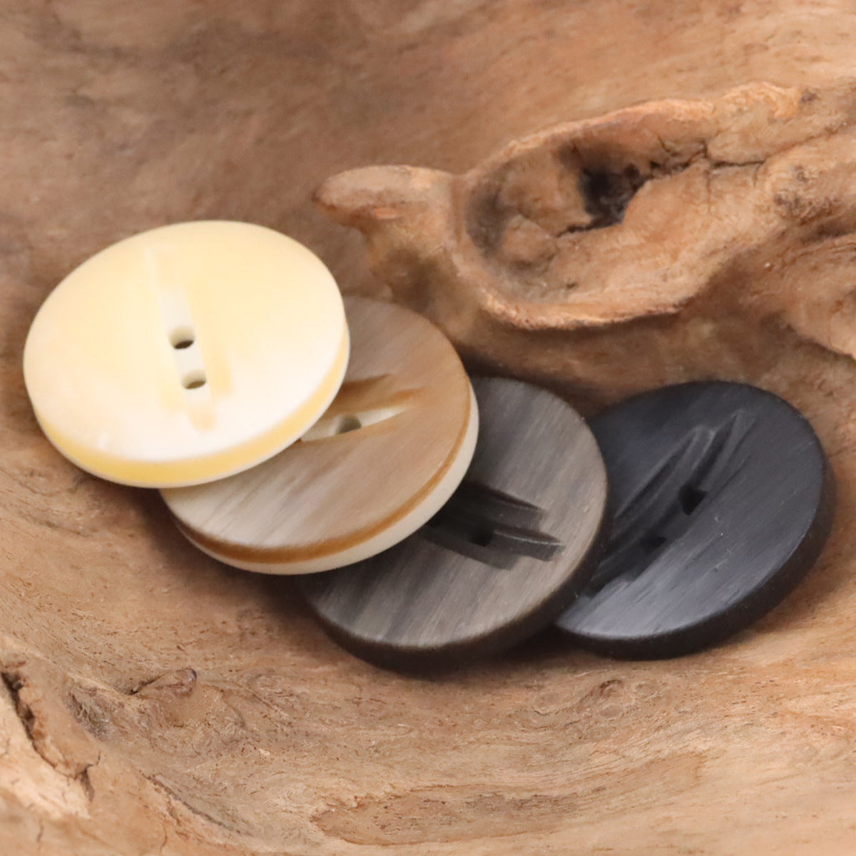 Assorted 2-hole wood-grain resin buttons in cream, brown, and dark gray